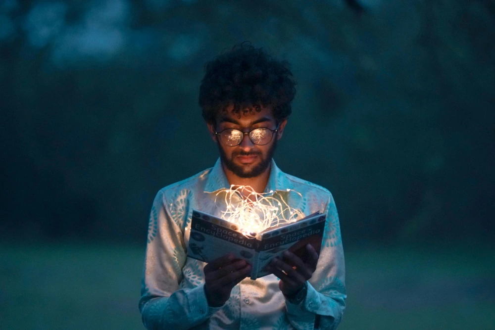 Ragazzo con un libro illuminato nella natura